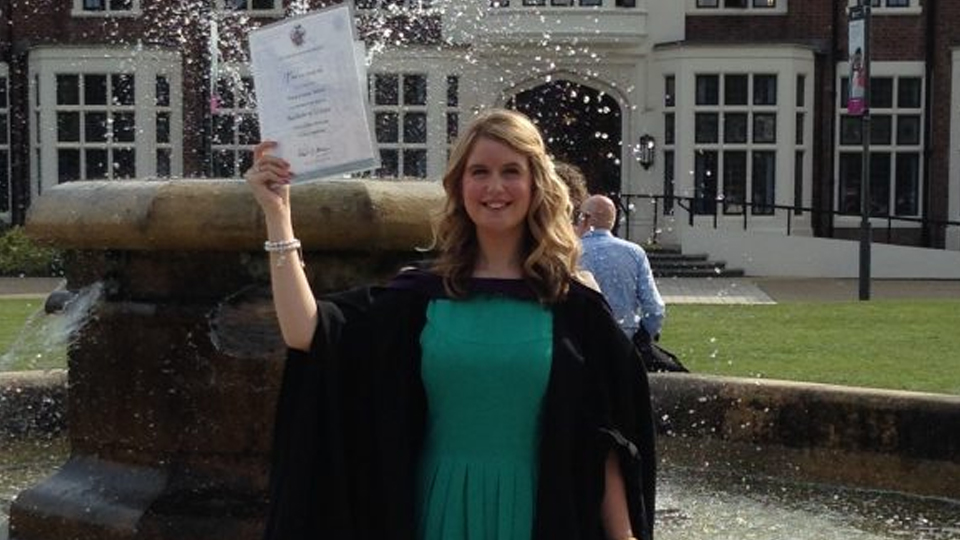 Amy Ward pictured at the Hazlerigg fountain in a graduation gown